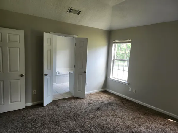 an empty room with windows and closet