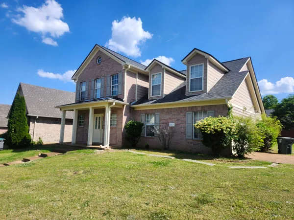 a front view of a house with a garden