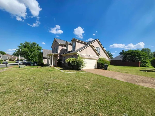 a view of a house with a yard and garage