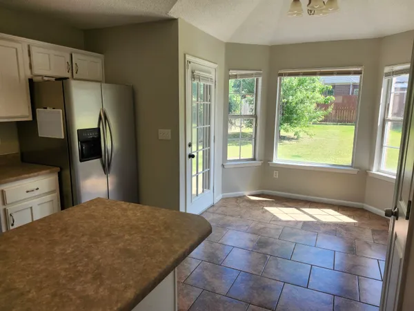 a spacious bathroom with a granite countertop sink and a large mirror