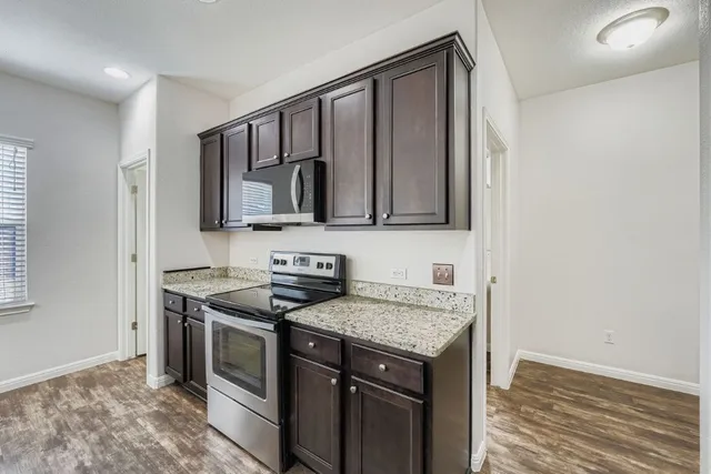 a kitchen with stainless steel appliances granite countertop a sink stove and microwave