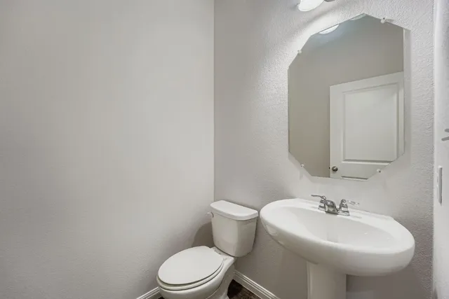 a bathroom with a sink a toilet and mirror