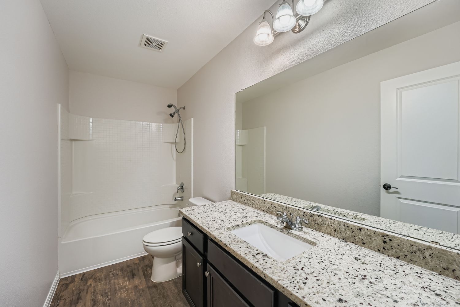 14013 Mark Christopher Way Manor, TX 78653 - Photo 21 of 28 a bathroom with a granite countertop sink a toilet and shower