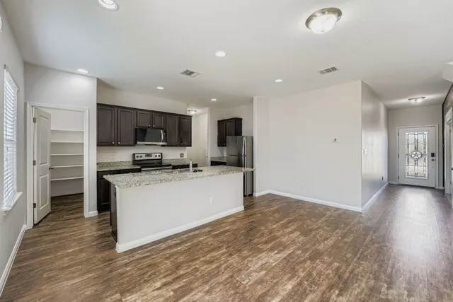 a large kitchen with a large window and stainless steel appliances