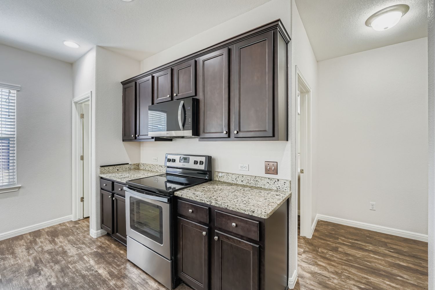 14013 Mark Christopher Way Manor, TX 78653 - Photo 9 of 28 a kitchen with stainless steel appliances granite countertop a sink stove and microwave