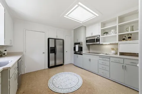a kitchen with stainless steel appliances granite countertop a sink refrigerator and cabinets