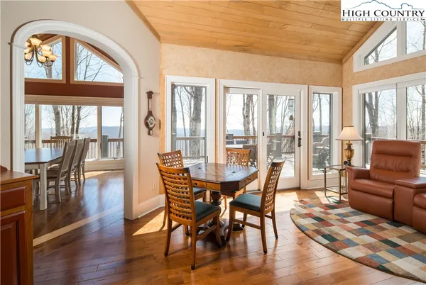a view of a dining room with furniture large windows and wooden floor