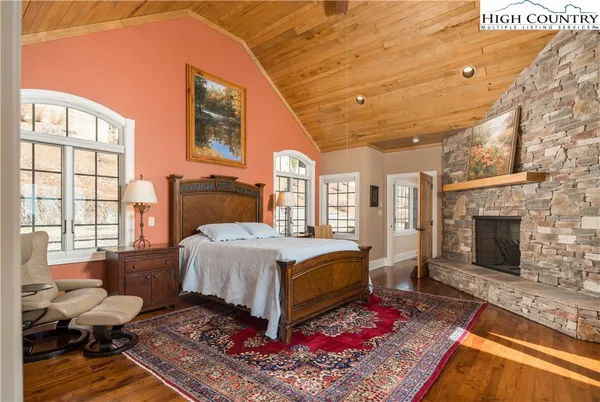 a spacious bedroom with a bed and wooden floor