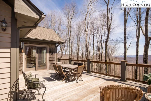 a view of a patio with a table chairs and wooden fence