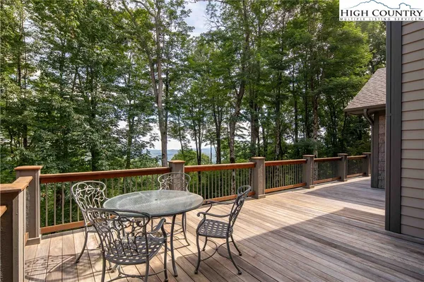 a balcony with wooden floor table and chairs