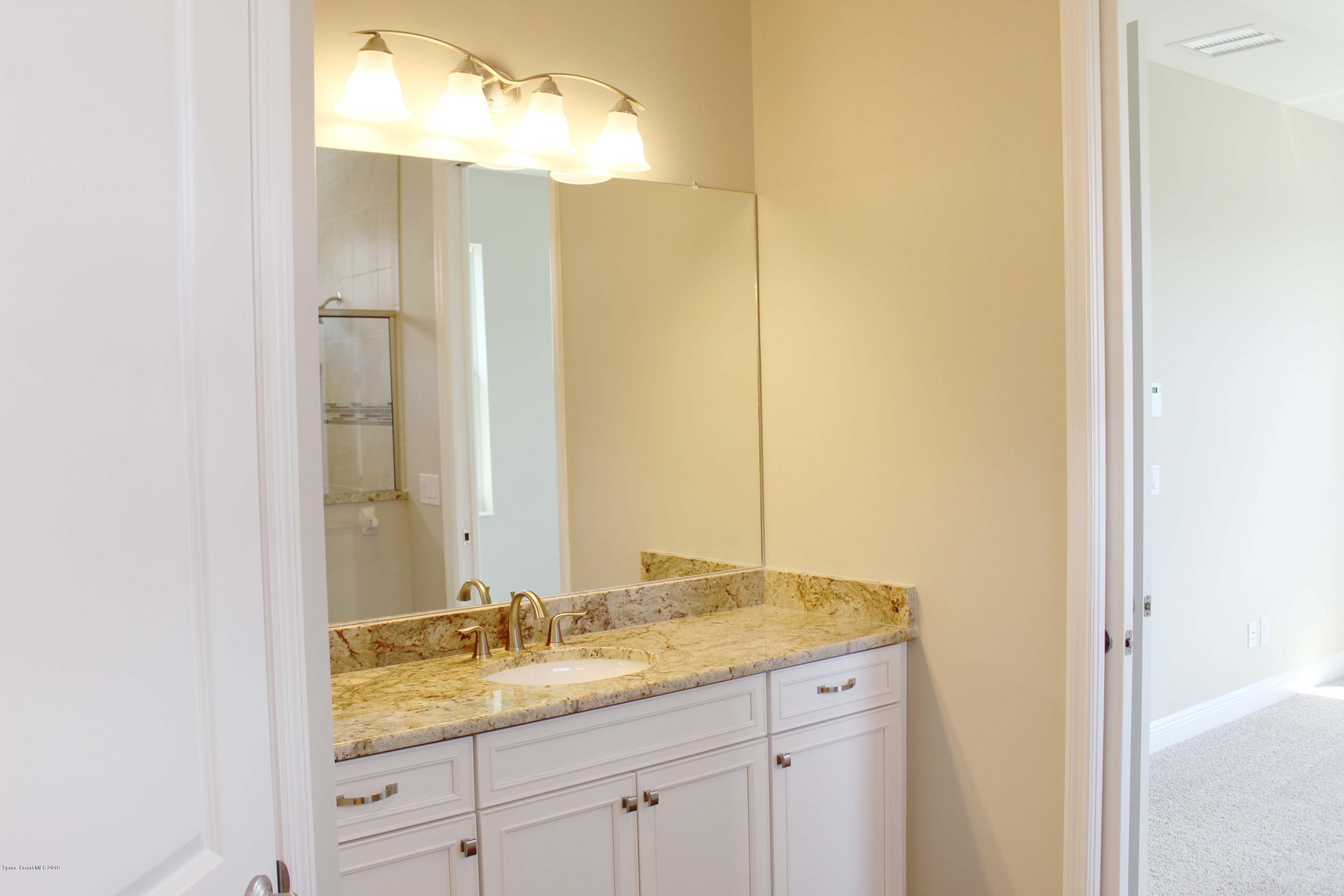 3631 Stabane Place Melbourne, FL 32940 - Photo 11 of 47 a bathroom with a granite countertop sink and a mirror