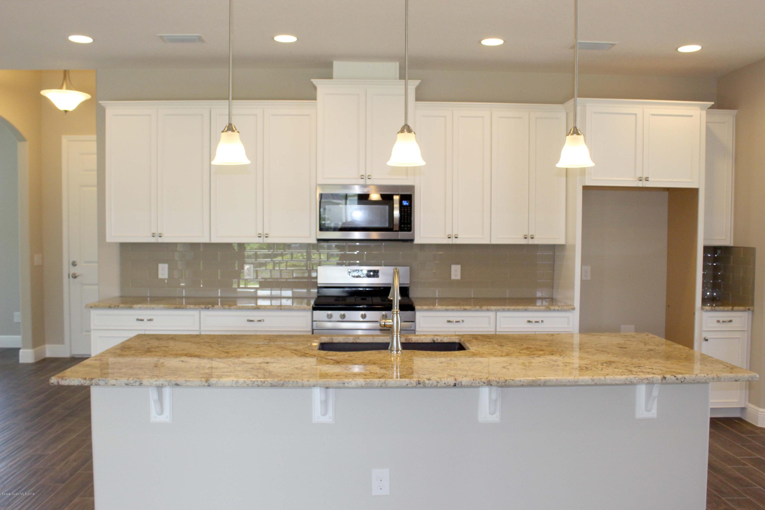 3631 Stabane Place Melbourne, FL 32940 - Photo 5 of 47 a kitchen with a sink a counter top space cabinets and stainless steel appliances