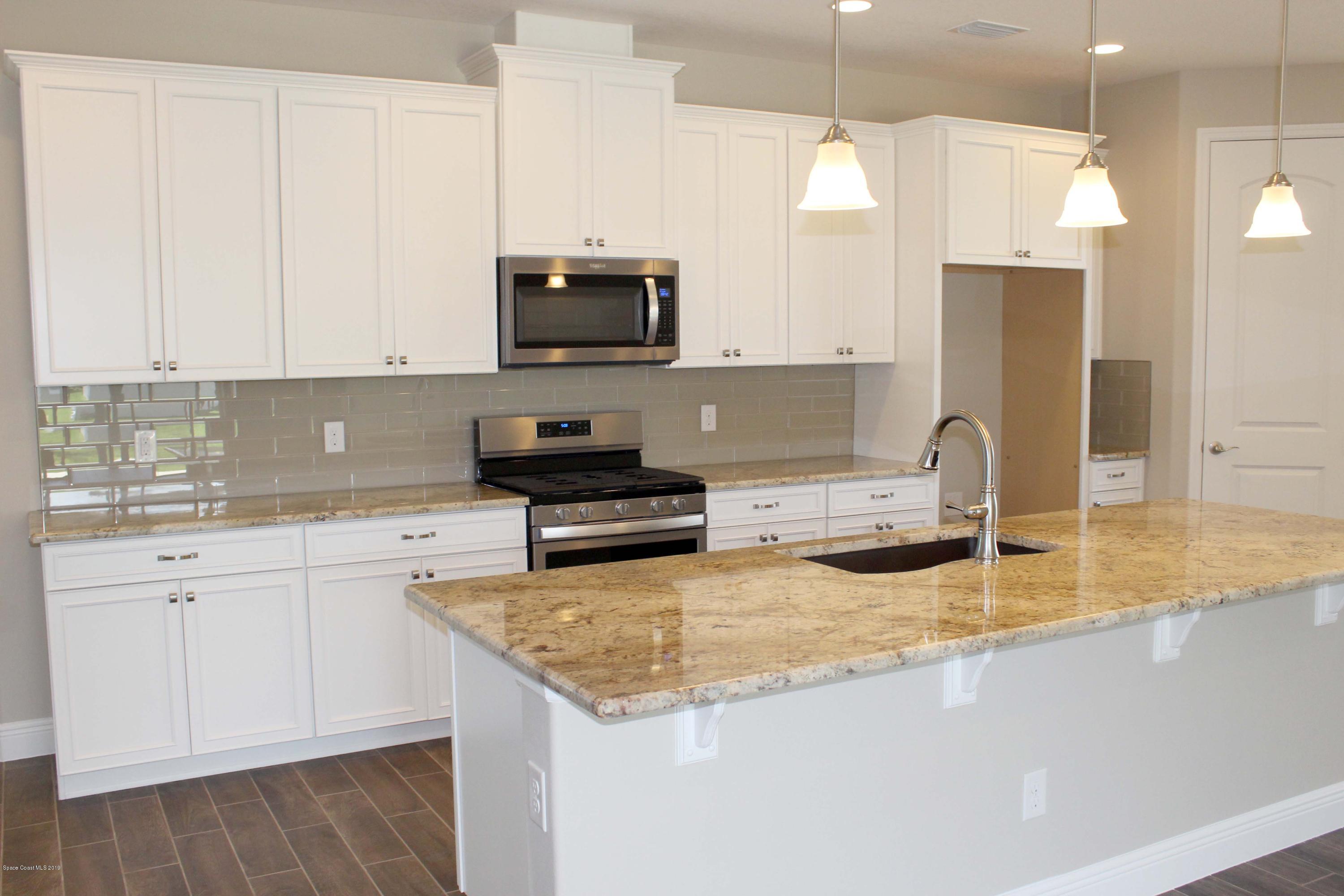 3631 Stabane Place Melbourne, FL 32940 - Photo 6 of 47 a kitchen with stainless steel appliances granite countertop a sink a stove and microwave