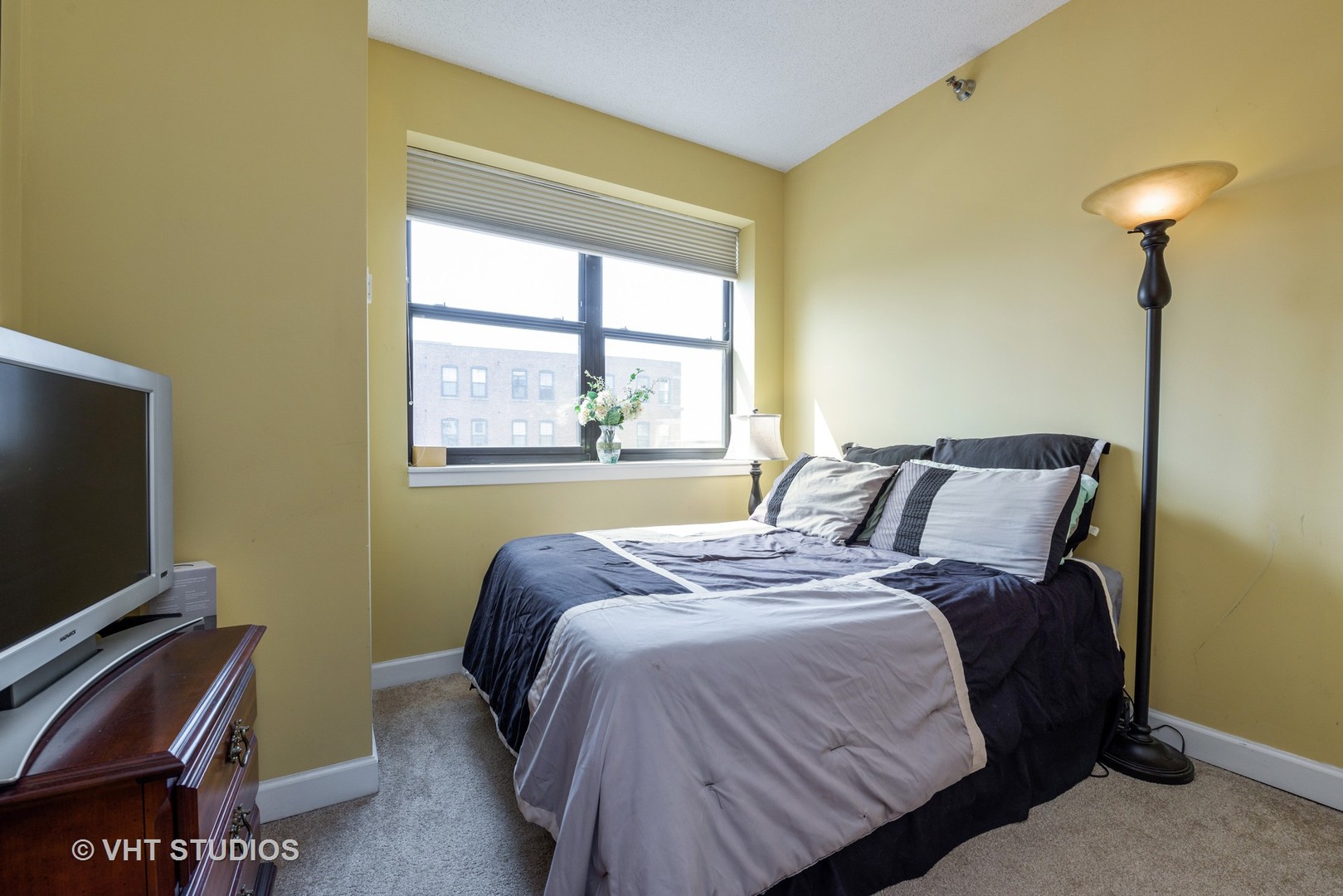 1529 South State Street, Unit 8B Chicago, IL 60605 - Photo 8 of 11 a bedroom with a bed and a flat tv screen on a dresser