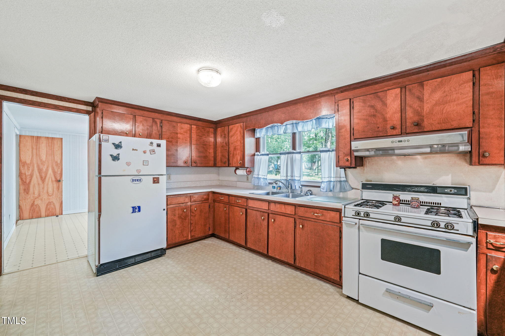 3015 Old Raleigh Road Apex, NC 27502 - Photo 16 of 47 a kitchen with a stove a sink and a refrigerator