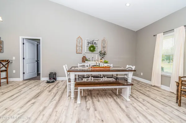 a living room with a table and chairs with wooden floor