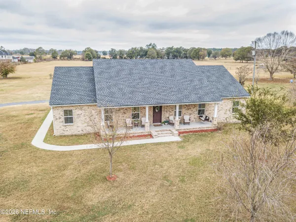 a kitchen with stainless steel appliances granite countertop a stove a sink dishwasher and white cabinets with wooden floor