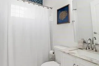 a bathroom with a granite countertop sink mirror vanity and toilet