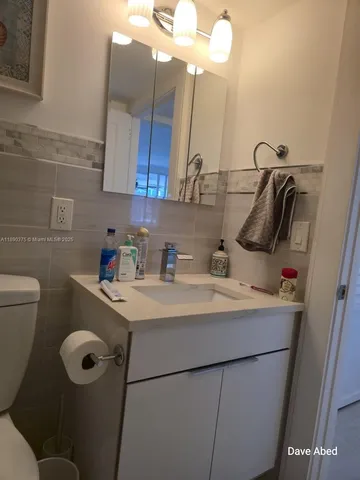 a bathroom with a sink toilet and mirror