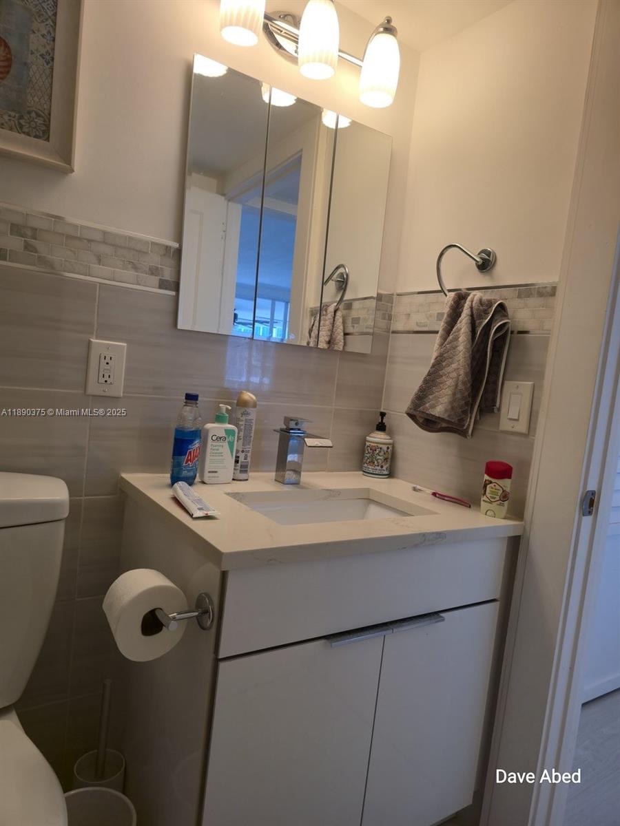 3600 Galt Ocean Drive, Unit 14C Fort Lauderdale, FL 33308 - Photo 13 of 22 a bathroom with a sink toilet and mirror