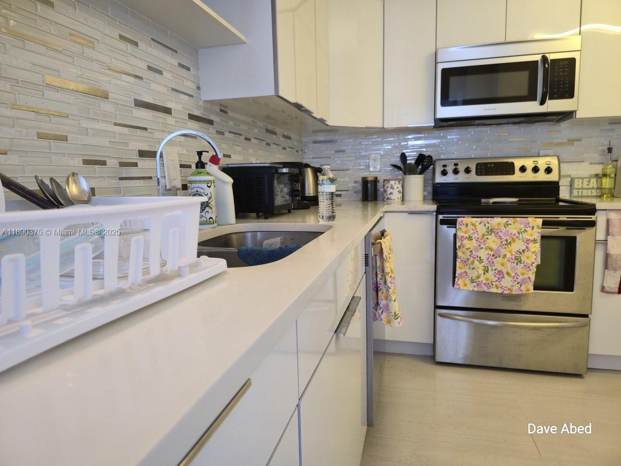 3600 Galt Ocean Drive, Unit 14C Fort Lauderdale, FL 33308 - Photo 3 of 22 a kitchen with stainless steel appliances kitchen island a stove and a microwave