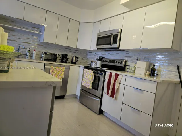 a kitchen with appliances a sink and cabinets