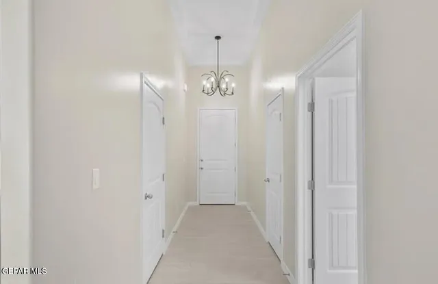 a view of a hallway with chandelier and entryway