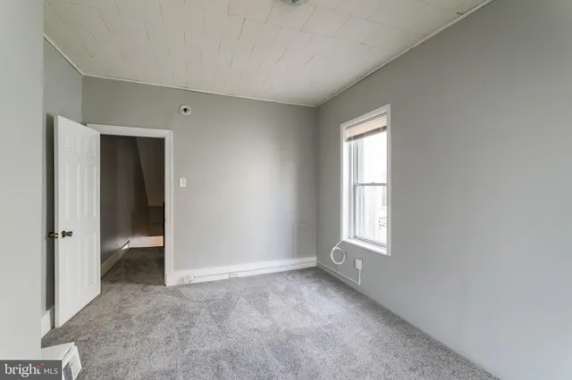 an empty room with windows and closet