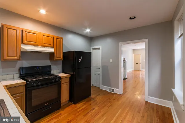 a kitchen with wooden floors and black appliances