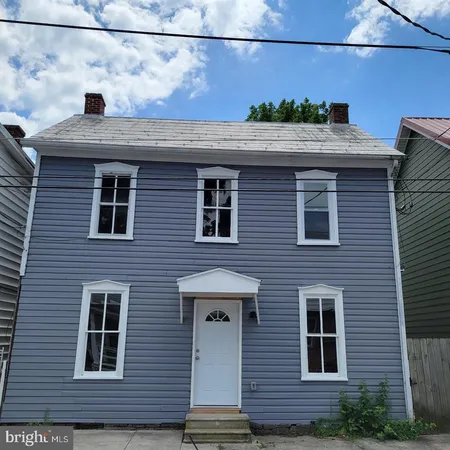 a front view of a house with a street