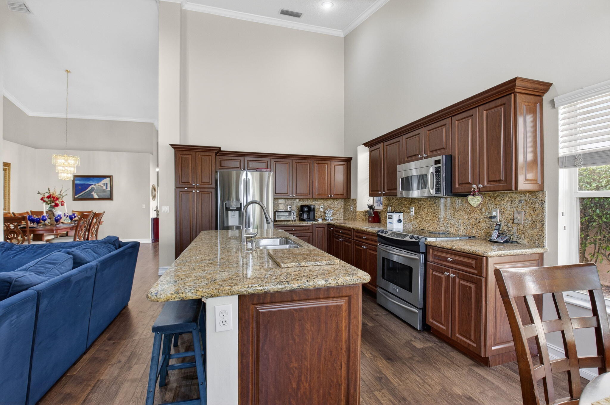 8361 Horseshoe Bay Road Boynton Beach, FL 33472 - Photo 19 of 73 a kitchen with kitchen island granite countertop wooden cabinets a stove a sink and dishwasher