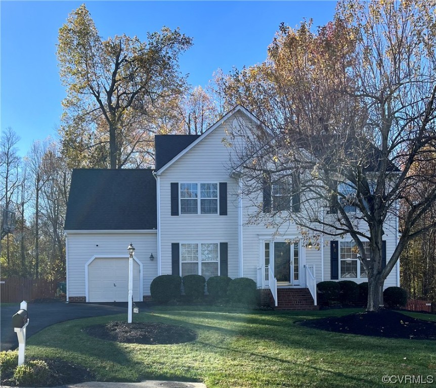 a front view of a house with a garden and trees