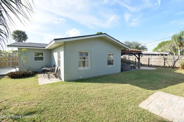 a backyard of a house with table and chairs