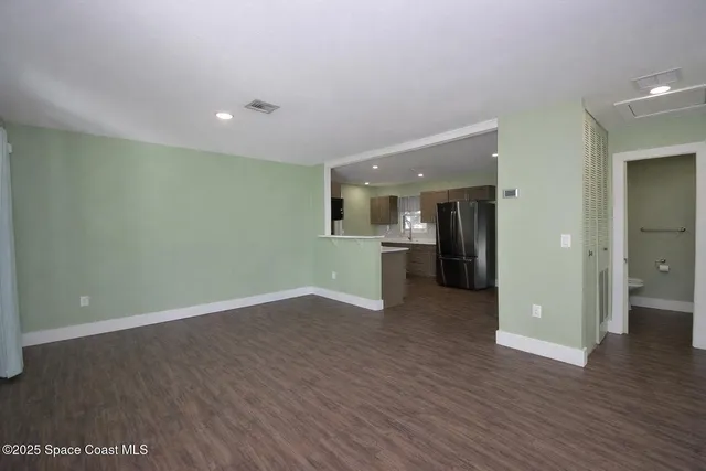 a view of a kitchen with a sink and a refrigerator