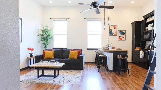 a living room with furniture a flat screen tv and a window