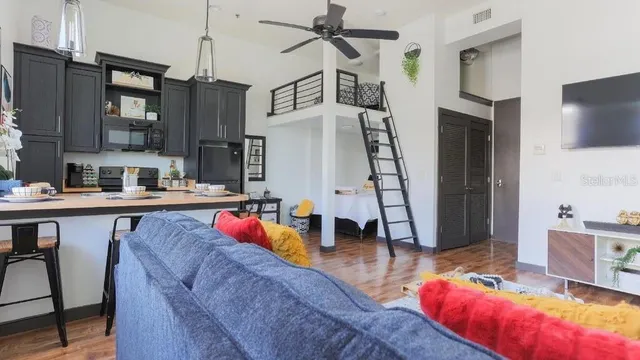 a living room with stainless steel appliances kitchen island granite countertop furniture and a view of kitchen
