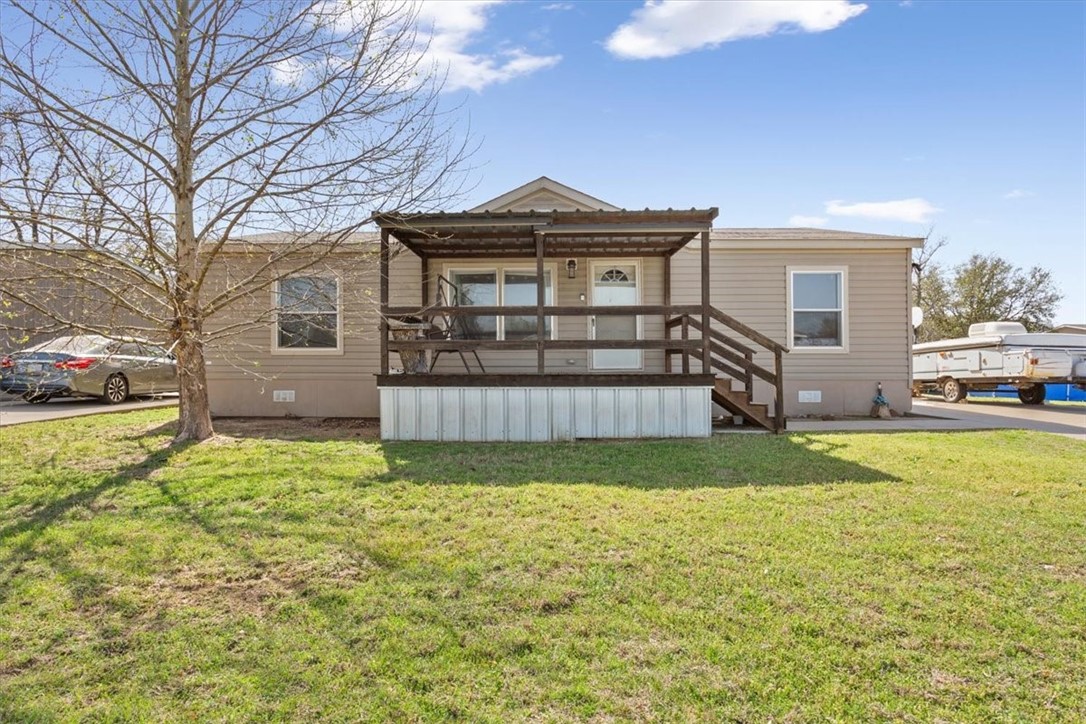 a view of a big house with a big yard and large trees