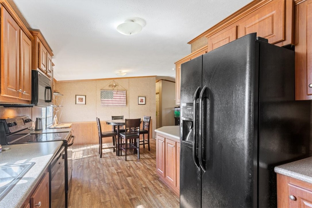 4517 Rocking K Drive Waco, TX 76705 - Photo 11 of 25 a kitchen with stainless steel appliances granite countertop a refrigerator a stove a sink a dining table and chairs with wooden floor