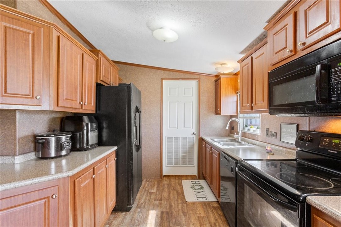 4517 Rocking K Drive Waco, TX 76705 - Photo 10 of 25 a kitchen with stainless steel appliances granite countertop a stove a sink dishwasher and a refrigerator with wooden cabinets