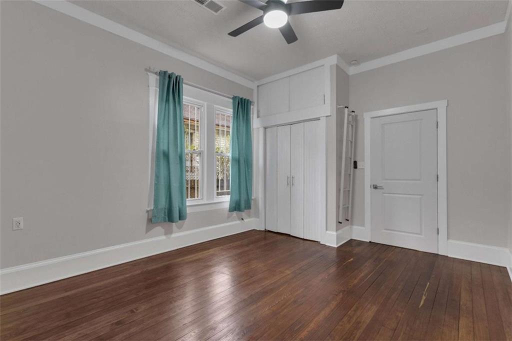 1286 Allene Avenue Southwest Atlanta, GA 30310 - Photo 27 of 49 an empty room with wooden floor chandelier fan and windows