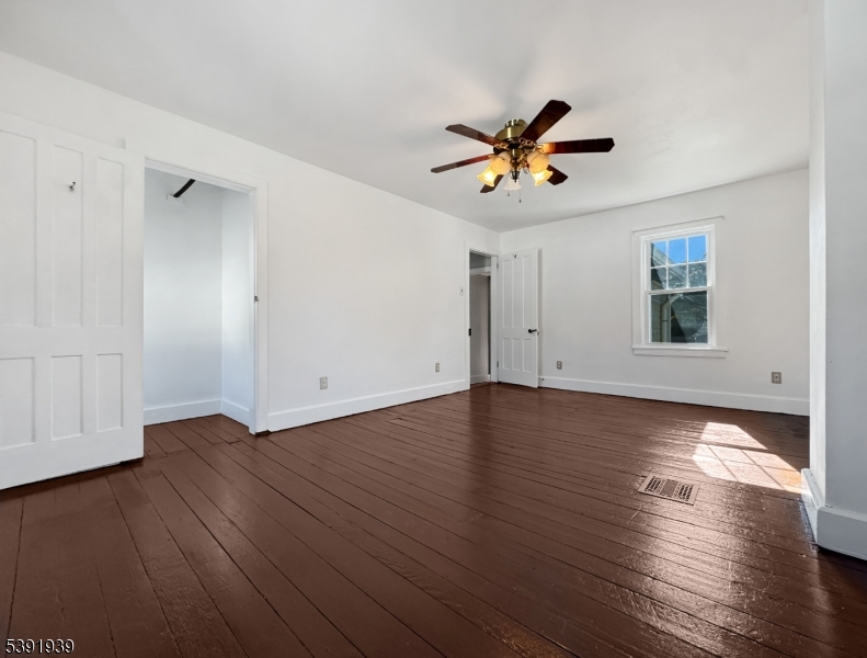54 Front Street Belvidere, NJ 07823 - Photo 14 of 32 an empty room with wooden floor chandelier fan and windows