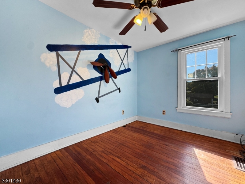 54 Front Street Belvidere, NJ 07823 - Photo 20 of 32 a view of a room with wooden floor ceiling fan and windows