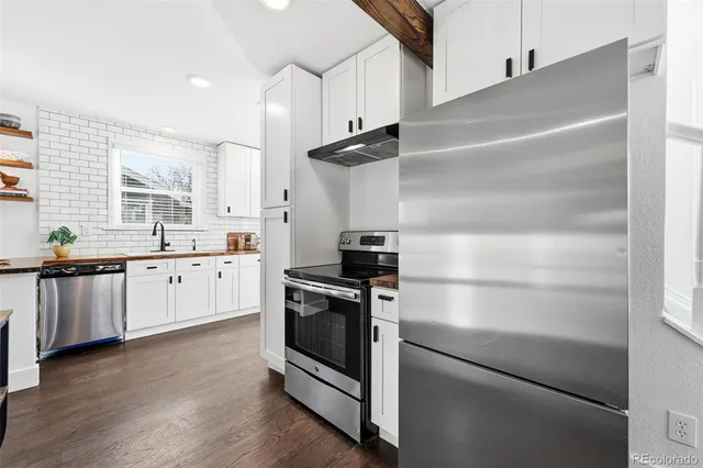 a kitchen with stainless steel appliances and white cabinets