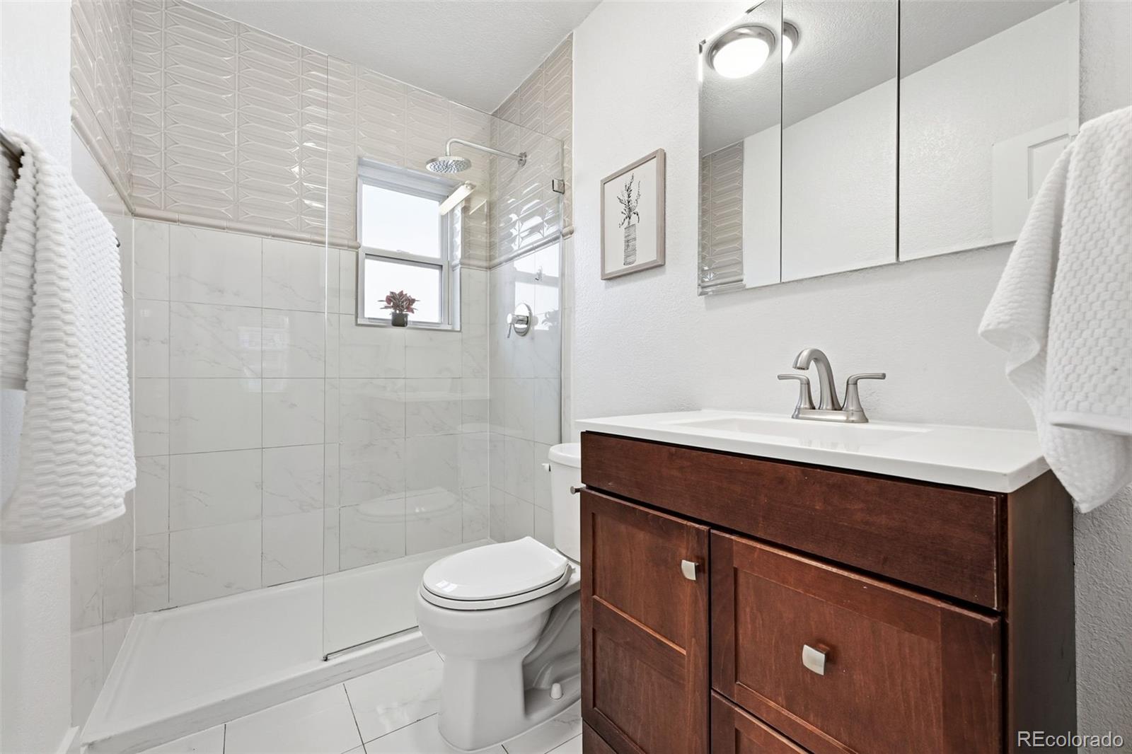 1661 Trenton Street Denver, CO 80220 - Photo 18 of 50 a bathroom with a sink a toilet and shower
