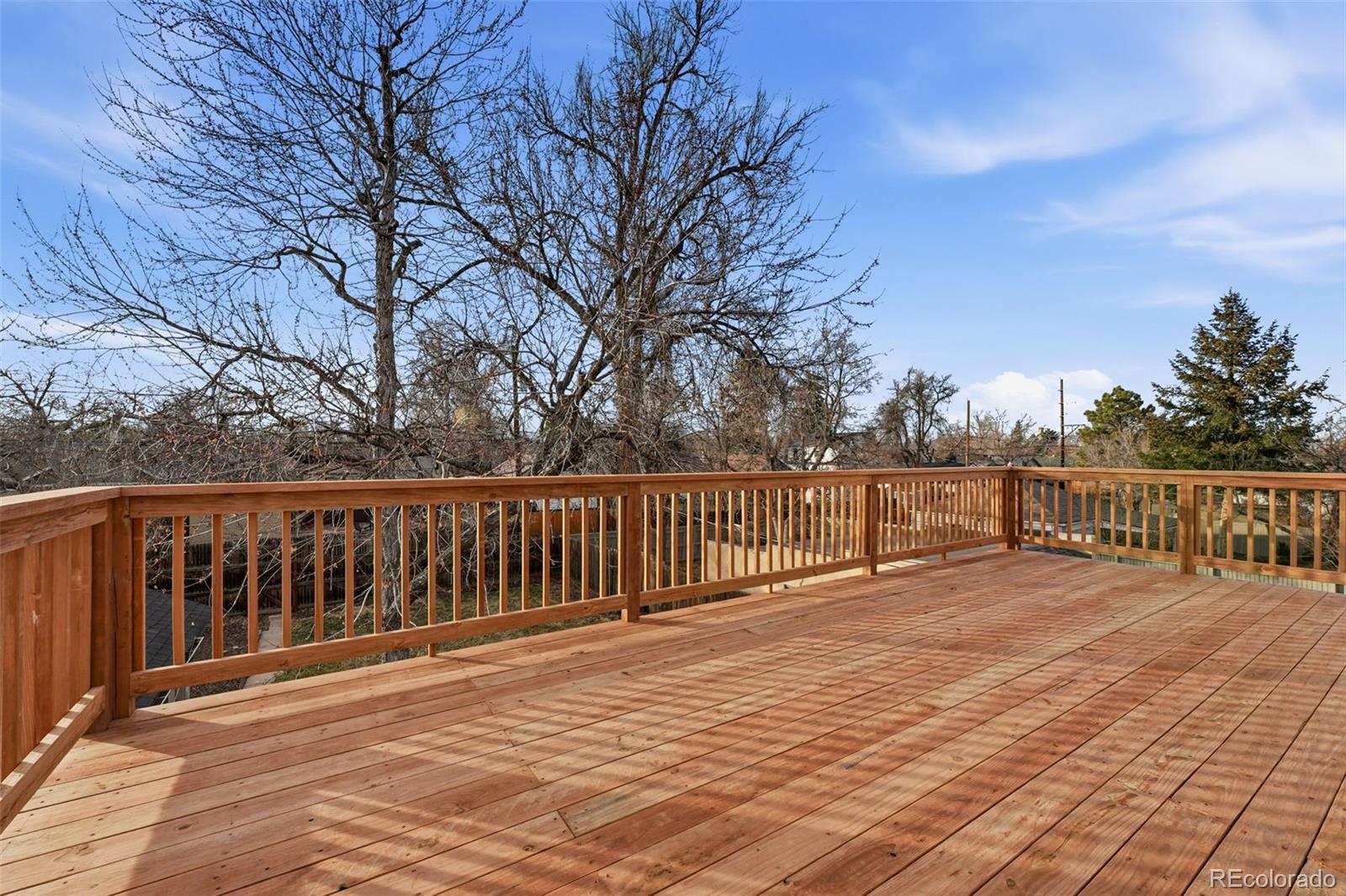 1661 Trenton Street Denver, CO 80220 - Photo 32 of 50 a view of deck with wooden floor and fence with trees