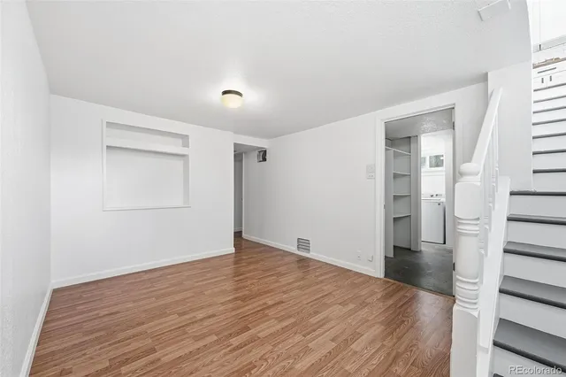 a view of an empty room with wooden floor