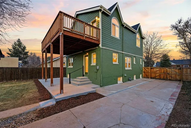 a view of a house with a small yard and wooden fence