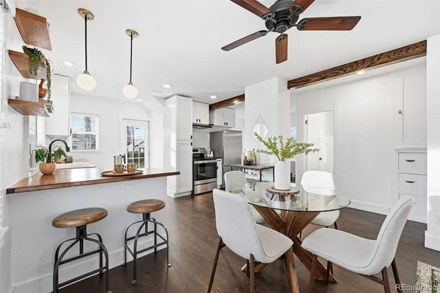 a view of a dining room and livingroom with furniture wooden floor a chandelier