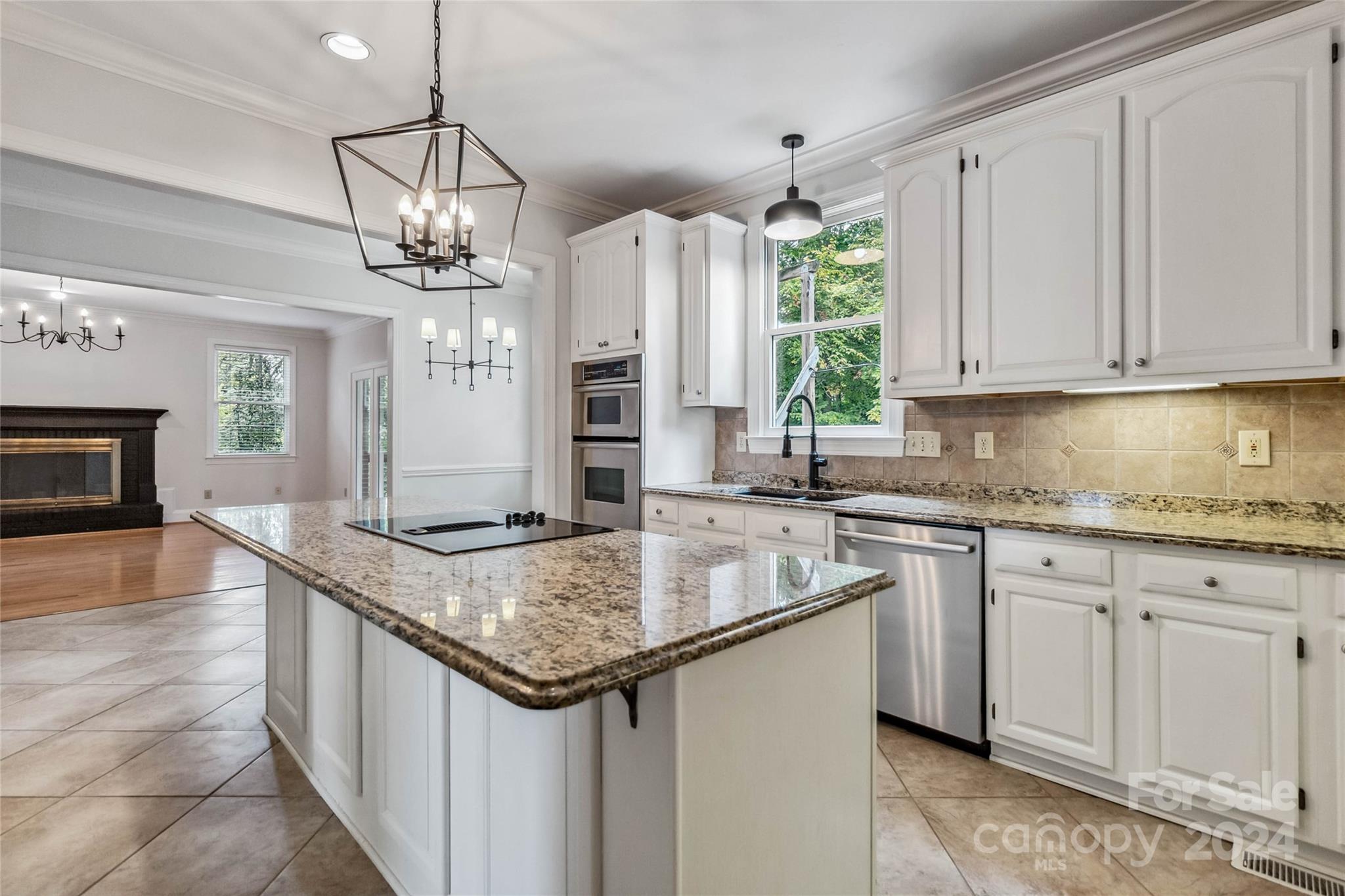 2410 Sharon Road Charlotte, NC 28211 - Photo 13 of 32 a kitchen with stainless steel appliances granite countertop a sink dishwasher and white cabinets with wooden floor