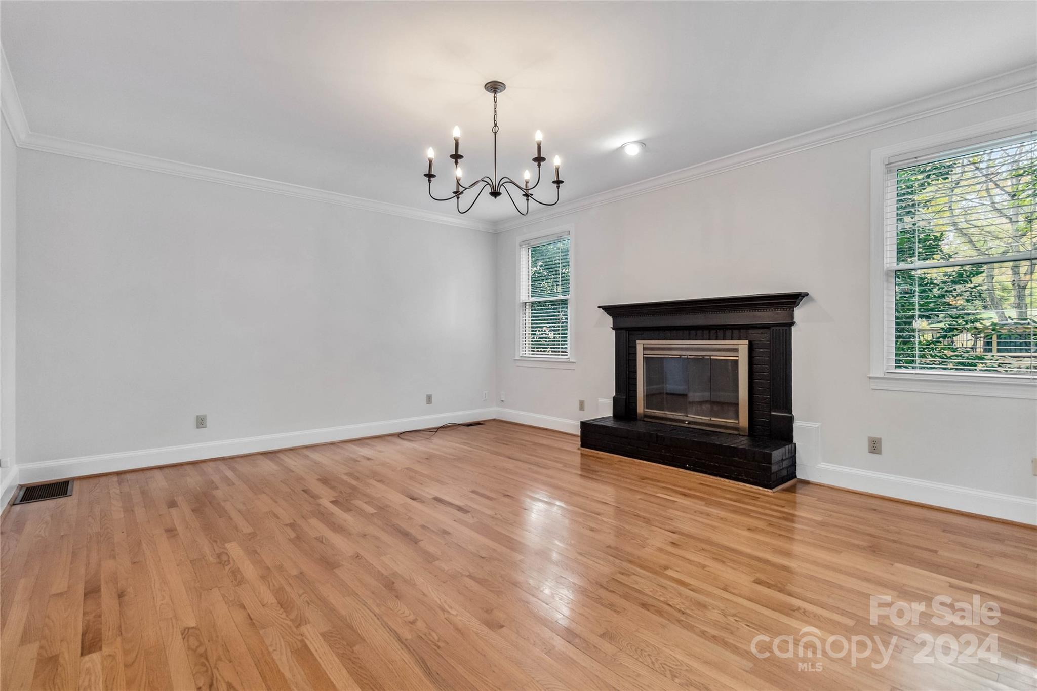 2410 Sharon Road Charlotte, NC 28211 - Photo 15 of 32 a view of empty room with wooden floor and fireplace